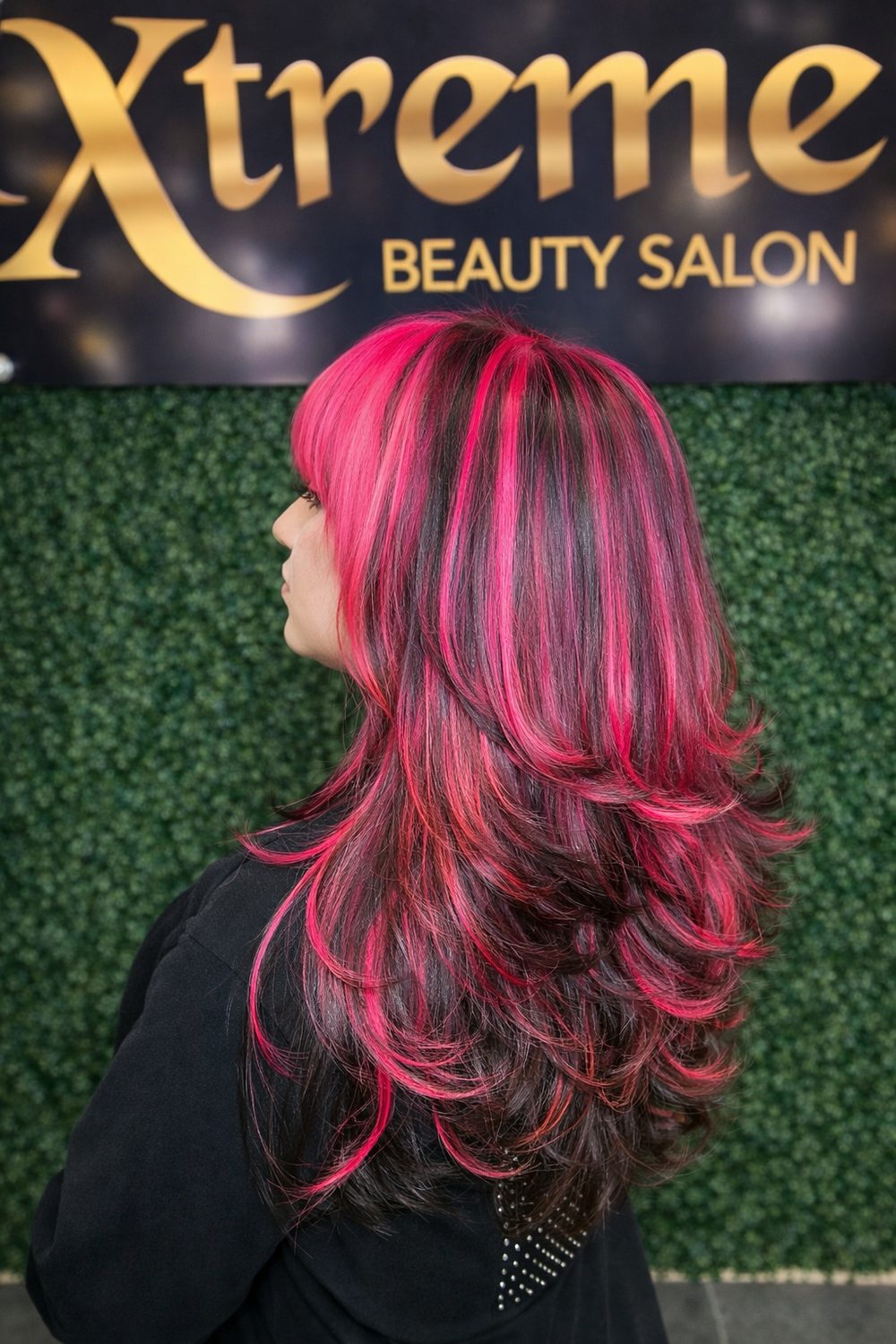 Black hair with hot pink highlights and layered cut