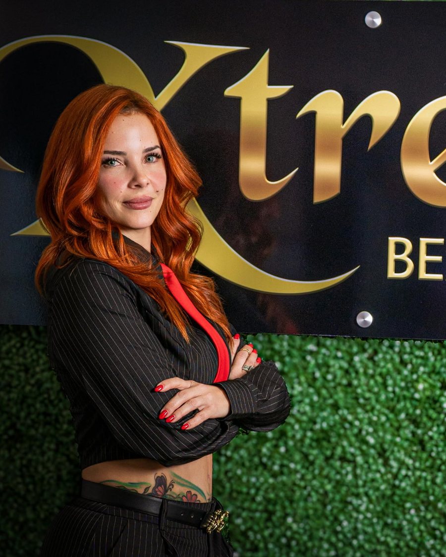 Mily Rojas in front of the Xtreme Beauty Salon sign
